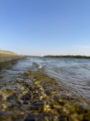 Obraz premium Low angle macro shot of ripples and small waves at the water edge