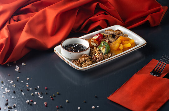 Georgian delicacies - churchkhela, nuts, dried figs, dried apricots. Served with nut jam.