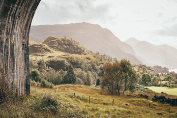 Naklejka premium The historic Glenfinnan Viaduct surrounded by lush green hills, Scottish Highlands
