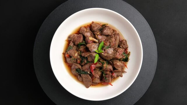 Stir fried chicken liver with holy basil leaves in white plate.Thai food.Top view.