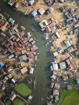 Aerial view of Ganvie stilt village with wooden boats navigating water channels between houses with corrugated metal roofs Ganvie, Atlantique, Benin.