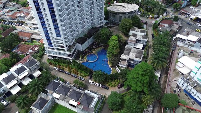 Aerial View of Modern Apartment Tower with Swimming Pool and Urban Neighborhood