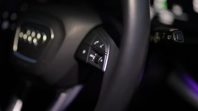 Close-up view of steering wheel of car control music. The hand turns the volume of the radio in the car. Close up of radio volume. Music in the car. Modern music technology