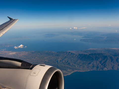 Aerial view of the Aegean Sea and the rugged coastline with mountains seen from an airplane window Greece.