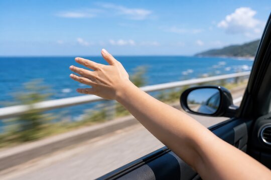 車窓から手を伸ばす海沿いドライブの夏