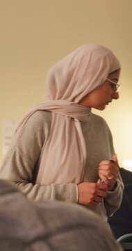 Woman, teacher and supervision with students in class for exam, invigilation and maintain discipline. Muslim, educator and observation to prevent cheating, academic assessment and monitoring behavior