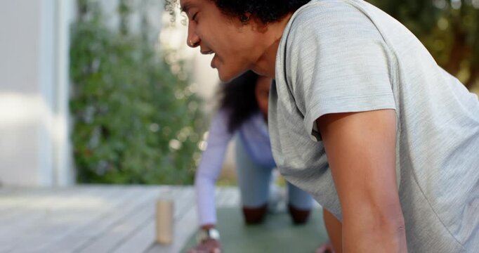 African American coach rising guiding student on deck mats urging plank matching breath, copy space
