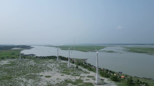 Cinematic aerial view of wind turbines beside Jamuna River Bangladesh