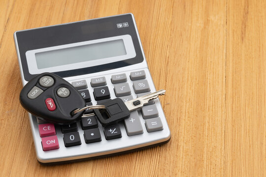 Car keys and calculator on wood desk