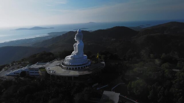 Drone survey over Big Buddha and surroundings with wide aerial framing showing terraces with vegetation and coastal line. Amazing landscape in Thailand with its famous architecture and landmarks