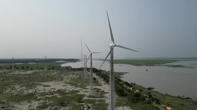 Cinematic aerial view of wind turbines beside Jamuna River Bangladesh