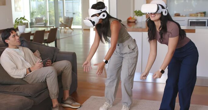 Diverse friends starting VR game on tablet, women wearing headsets reaching and crouching at home