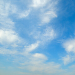 Fototapeta premium Beautiful panoramic view of a bright blue sky filled with soft white wispy cumulus clouds on a clear summer day, offering a tranquil and peaceful natural background.