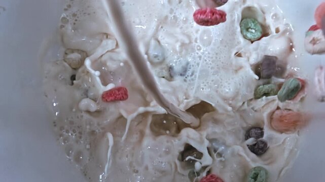 Puring milk and Colorful Fruity Cereal Loops at slow motion