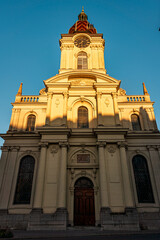 Fototapeta premium Saint Louis Church Clock Tower Illuminated by Golden Sunset Light in Switzerland.
