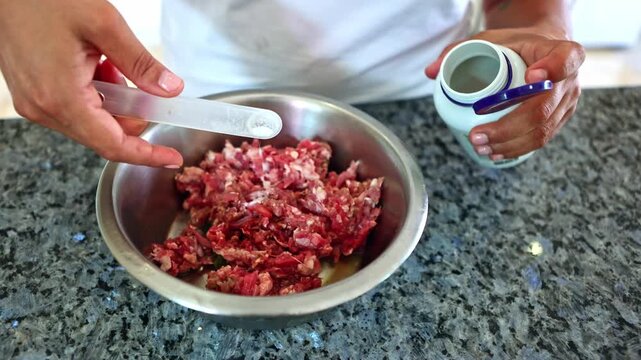 Person preparing raw BARF diet for dogs adding supplements