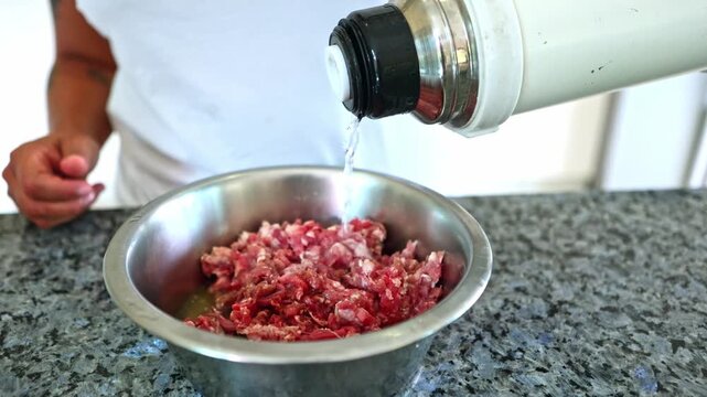 Person preparing a BARF diet meal for a dog with minced meat