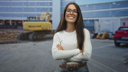 Fototapeta premium Woman gives thumbs up and points with finger in front of a construction building while smiling with arms crossed in other frames; confidence.