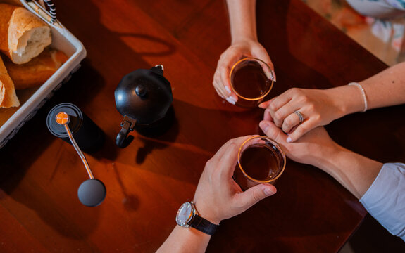 Pareja compartiendo caf&eacute; y desayuno mientras se toman de las manos en un momento rom&aacute;ntico y acogedor
