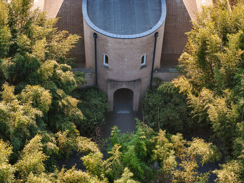 Fontanellato, Italy - 26 May 2026: Aerial view of Labirinto della Masone featuring a brick structure with an arched entrance surrounded by lush bamboo foliage.