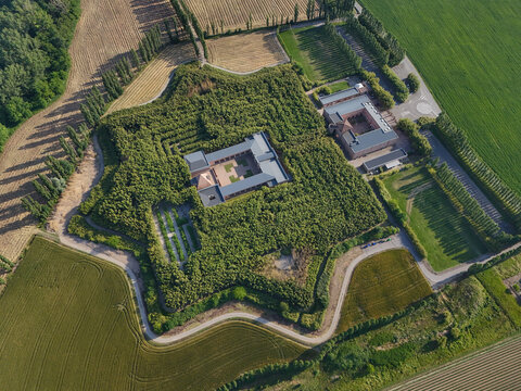 Fontanellato, Italy - 26 May 2026: Aerial view of Labirinto della Masone, the star-shaped bamboo maze with its central courtyard buildings and surrounding green fields.