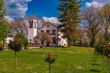 Naklejka premium Historic White Church Tower Among Spring Trees
