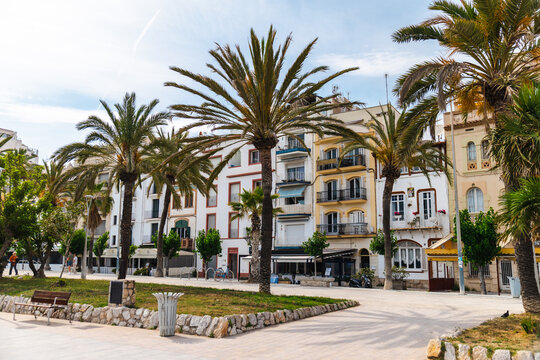 Palm lined promenade and residential buildings along Mediterranean waterfront in Sitges Spain