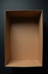 Fototapeta premium Empty open cardboard box on dark background. Brown corrugated container ready for storage, moving or shipping needs. Simple product packaging concept.