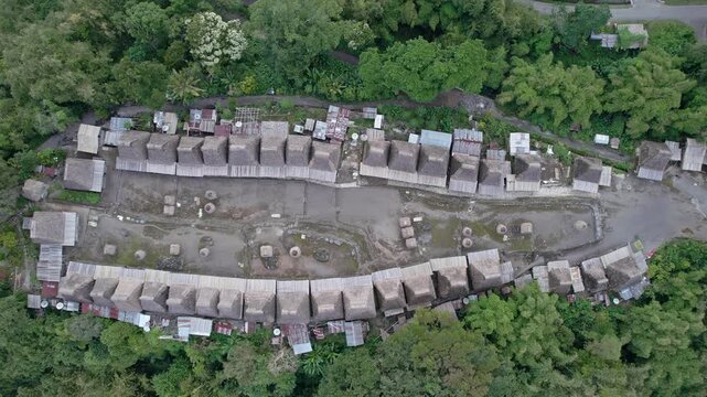 Aerial view of Bena Traditional Village with its iconic thatched roof houses arranged in rows surrounded by lush tropical forest Kecamatan Jerebuu, Nusa Tenggara Timur, Indonesia.