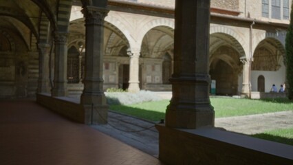Cloister courtyard with arched colonnade and stone pillar, softly defocused shallow bokeh, church  background copyspace backplate calm. © Krakenimages.com