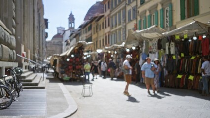 Obraz premium Outdoor market scene with soft defocused stalls and distant cathedral dome, blurred bokeh street; background backdrop copyspace template.