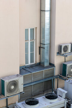 Air Conditioning Units and Ventilation Ducts on Beige Building Exterior Showing HVAC Equipment