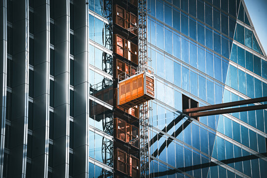 Modern skyscraper construction with external elevator and reflective glass facade