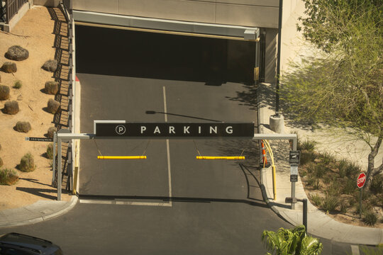 Entrance to a multi-level parking garage with clear signage and yellow clearance bars