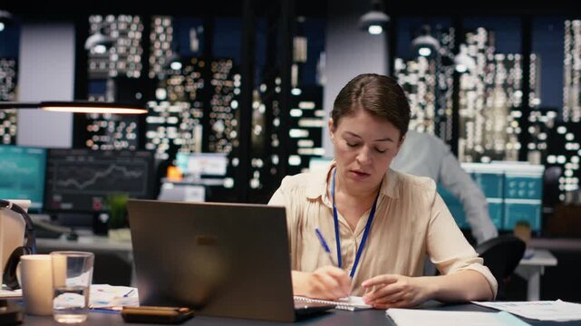 Anxious businesswoman tearing sheet of paper after writing incorrect data during late night work session. Worried manager struggles with stress, burnout and poor results, trying to find solution.