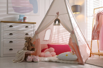 Cute wigwam, clothes, cushions and toy in stylish child's room © New Africa