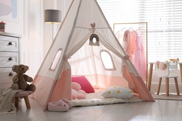 Cute wigwam, clothes, cushions and toy in stylish child's room © New Africa
