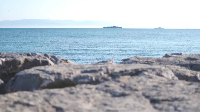 Scenic Sea Landscape View with Defocused Rocky Coast in the Foreground and Islands on Horizon Background for Text