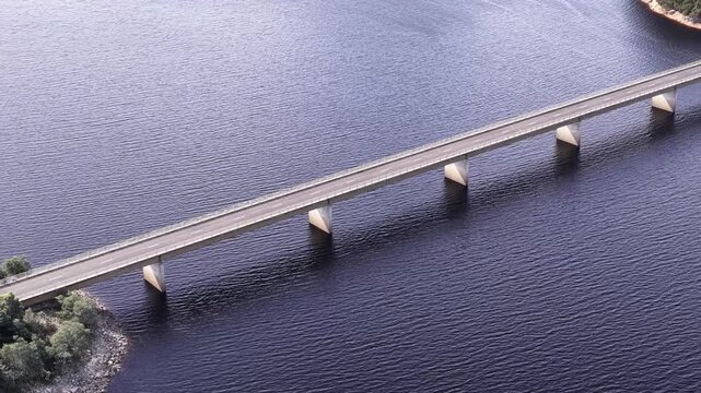 Zoom out from Burbury lake Bradshaw bridge on Lyell highway in Tasmania &ndash; aerial.