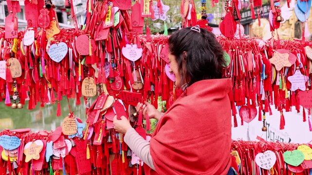 Woman enjoying chinese wishing plaques in an ancient village