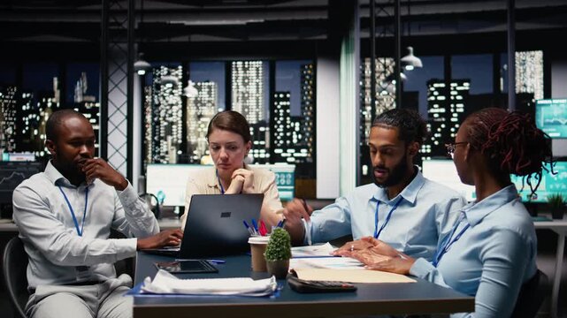 Multiethnic office coworkers reading emails on laptop in boardroom, ensuring project agenda. Cheerful employees analyzing data and KPIs on notebook, statistical information. Office life.