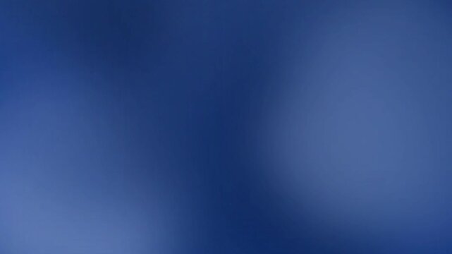 A deep, rich, sapphire blue gradient flows softly across the frame, transitioning from a vibrant, electric hue to a more muted, hazy indigo tone, creating a calming and serene visual atmosphere