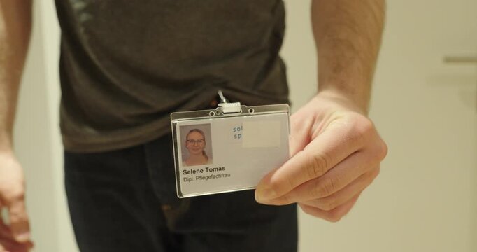 Employee Showing ID Badge Attached to Belt Clip Close Up