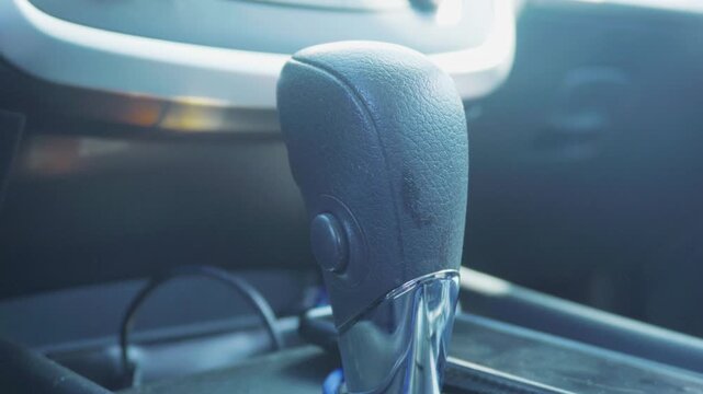 Sleek gear shift lever with textured black handle and shiny chrome base inside a contemporary vehicle&rsquo;s cabin