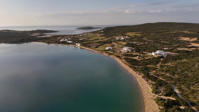4K drone flying backward revealing a secluded sandy bay with sailboats anchored, Paros, Greece