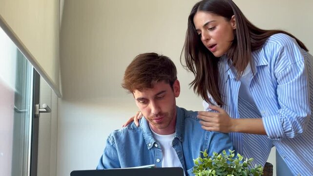 Young couple collaborates on a project at home, sharing ideas and discussing tasks. Focused on remote work or studying, they demonstrate teamwork and mutual support in a casual setting.