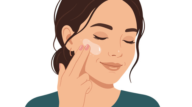 A woman with dark hair tied back gently applies a small amount of white skincare cream to her cheek using her index and middle fingers in a soft studio setting.