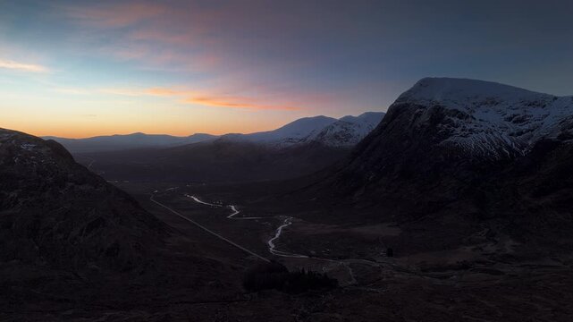 Winter aerial establishing shot of Glencoe mountain valley at sunrise
