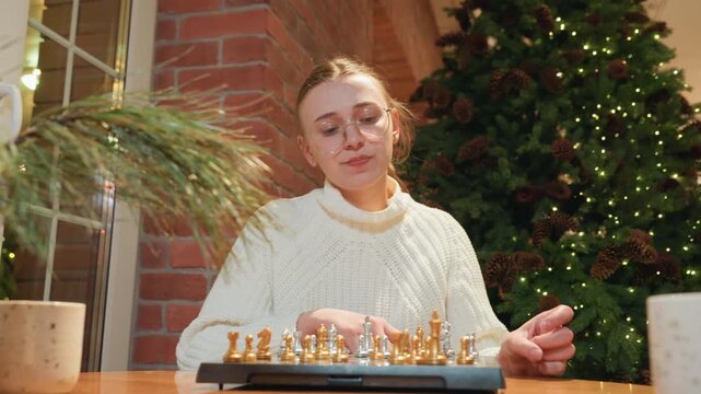 Indoor woman training her game. Focused female player deeply studying her chess tactics during match. Indoor scene where woman concentrates fully on her strategic chess decisionmaking process