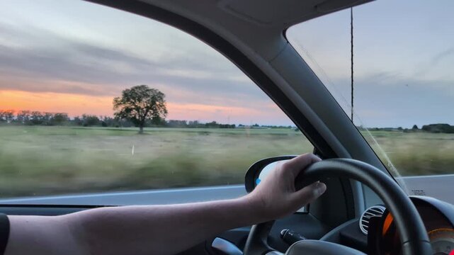 Male driver driving car, inside view. Man driving car on highway road at sunrise